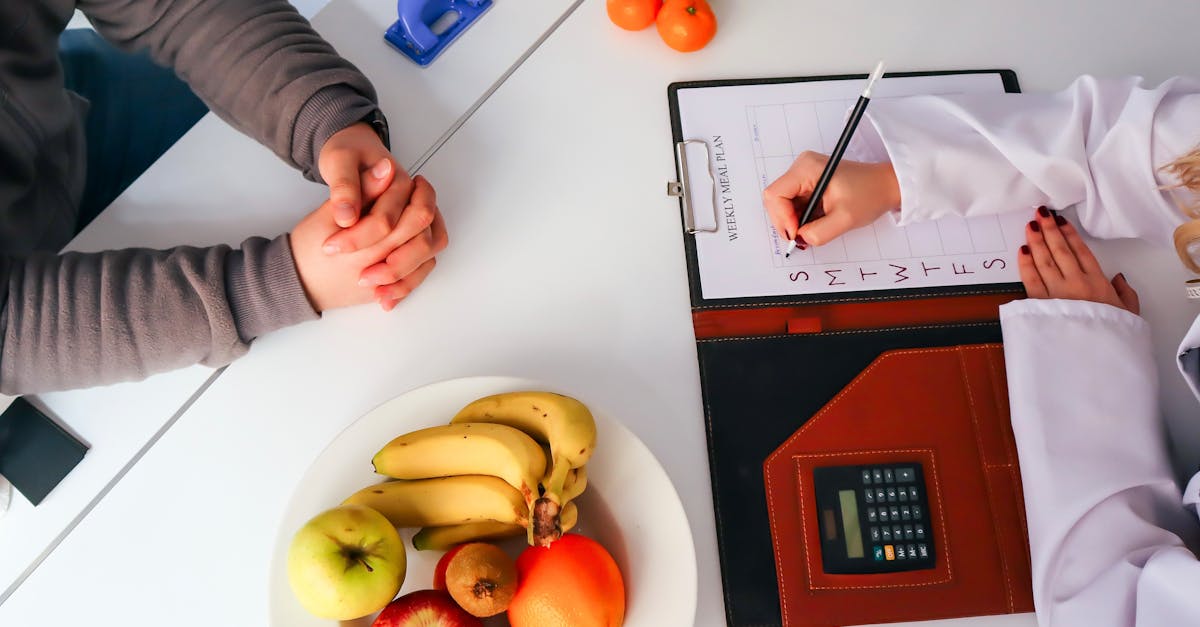 Top view of a dietitian planning a healthy diet with fresh fruits on the table, focusing on health and nutrition.
